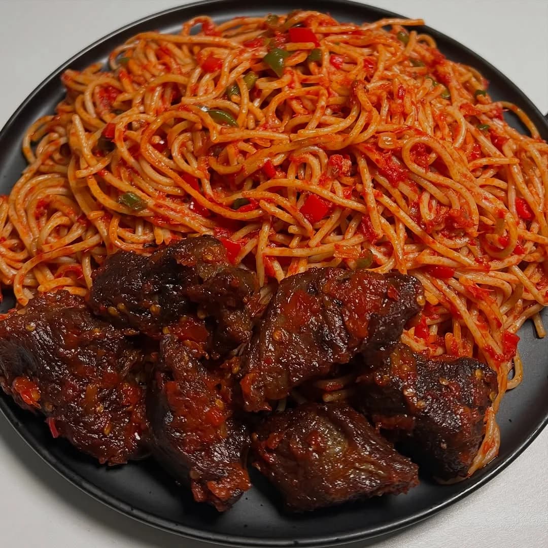 Jollof Spaghetti served with Plantain and chopped chicken